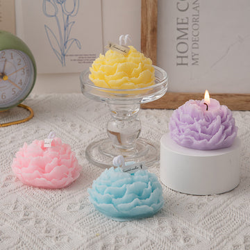 A handmade peony flower aromatherapy candle in a glass jar with a lit wick, showcasing soft floral design and warm glow.