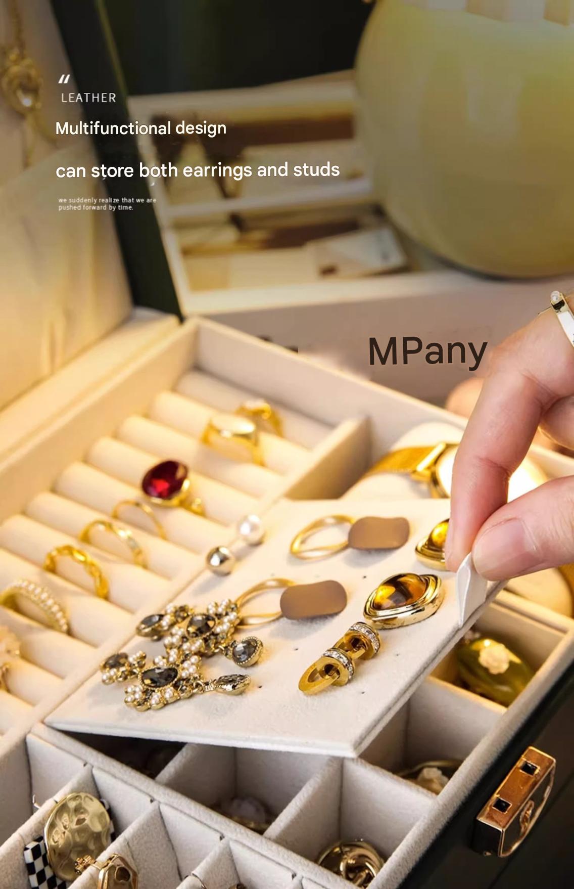 Large leather jewelry box with three-tier drawers, gold accents, and compartments for necklaces, earrings, and bracelets.