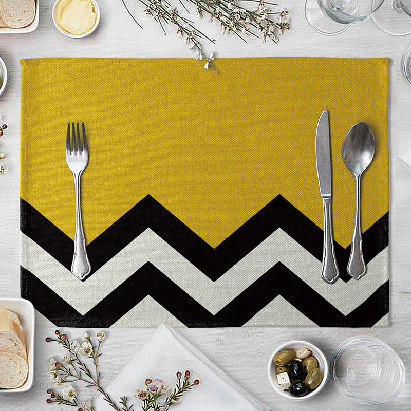 Aiqi geometric pattern dining table placemat with colorful triangular and square designs on a kitchen table.
